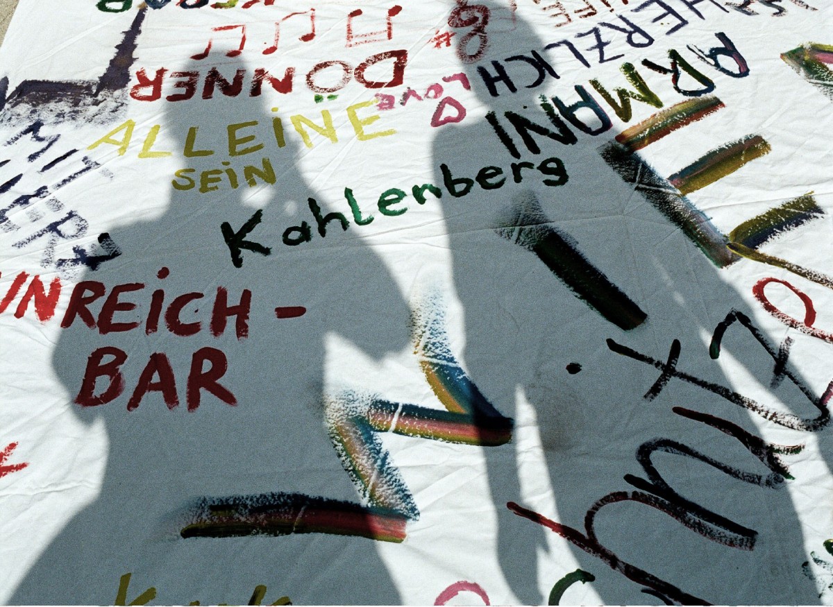 2 Schatten vor einem Bild, das mit unterschiedlichen Wörtern per Hand beschrieben wurde